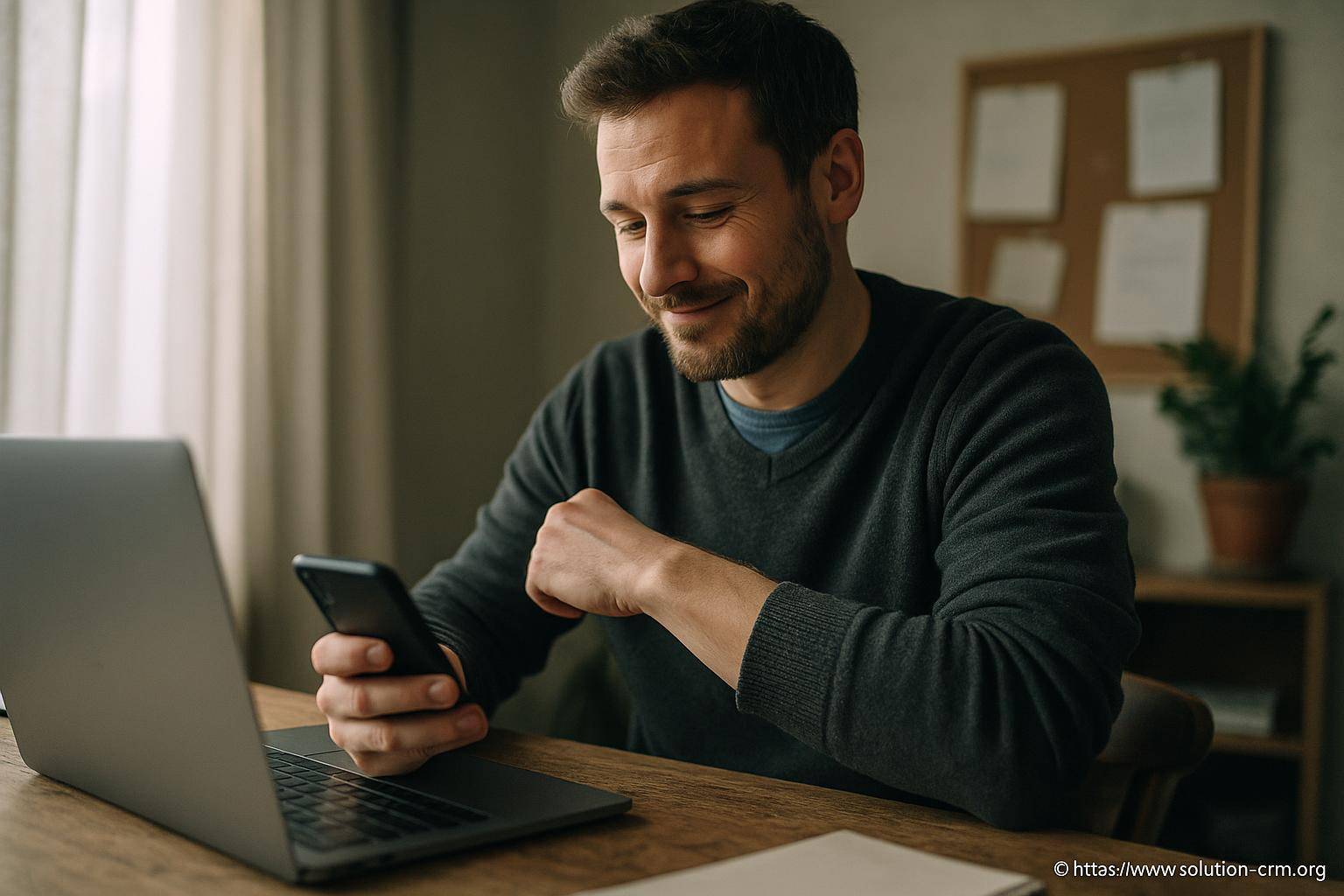 Homme souriant utilisant smartphone et ordinateur